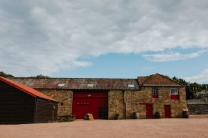 converted old barn with red painted windows and doors. 