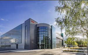 External shot of the EPAC building, which is a large modern 3 storey building with large curved window frontage. The rest of the building is clad in a mix of green and grey tile.